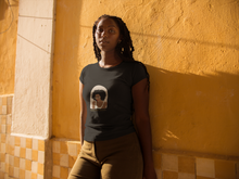 Load image into Gallery viewer, Woman wearing black t-shirt that has a woman with glass on the shirt and says "Knowledge Seeker"