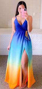 Woman wearing long colorful flowy dress with spaghetti straps