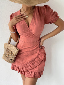 Woman wearing short dusty rose color wrap dress