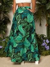 Load image into Gallery viewer, Woman wearing long green floral skirt with split on the side