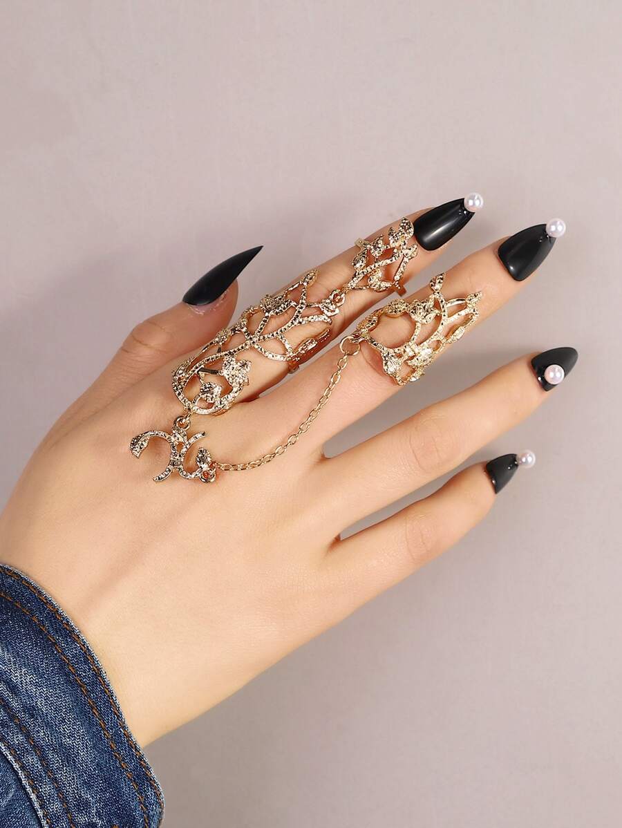 Woman's hand wearing gold flower vine finger chain