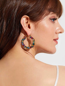 Woman wearing multicolor gemstones hoops
