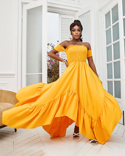 Woman wearing long yellow flowy strapless halter dress