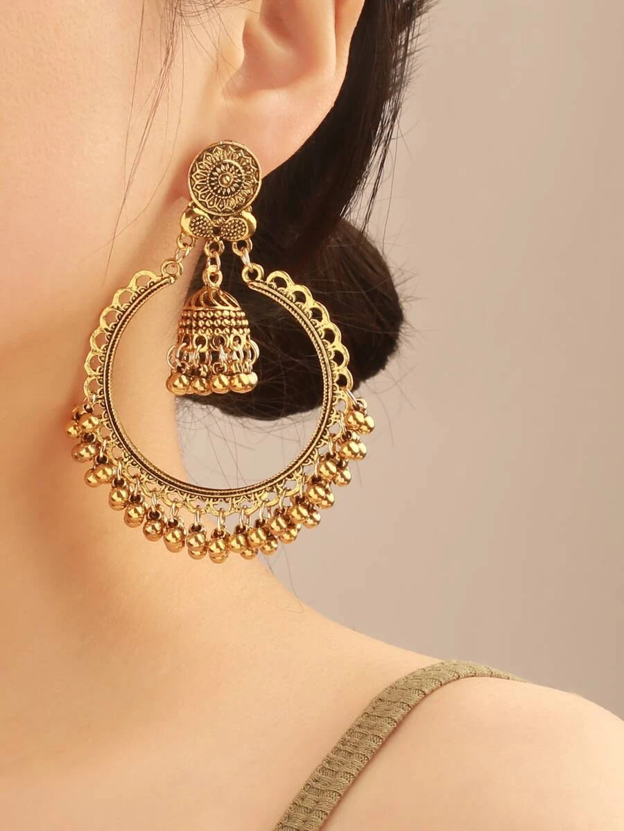 Woman wearing gold jhumka design earrings