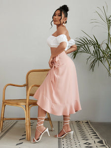 Woman wearing white off-shoulder top and pink long skirt