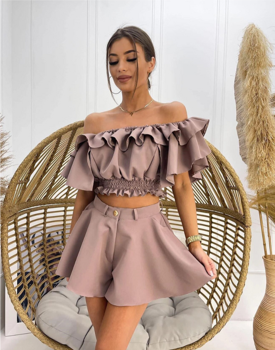 Woman wearing off-shoulder mauve color ruffle top and shorts