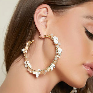 Woman wearing stone and crystal hoop earrings