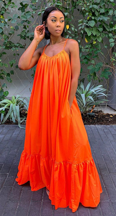 Woman wearing orange spaghetti strap long dress