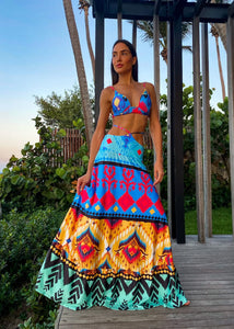 Woman wearing multicolor tribal print crop top and long flowy skirt