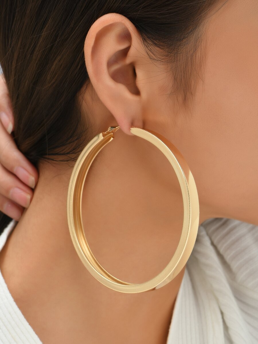 Woman wearing big gold hoop earrings