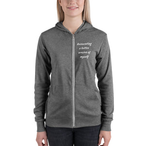 Woman wearing gray hoodie that says "Reinventing a better version of myself" on front